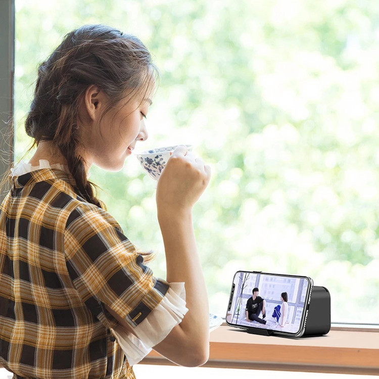 ساعت ال ای دی ۳ کاره NIVA کاربر خانم در حال استفاده از هولدر محصول و تماشای فیلم روی میز کار