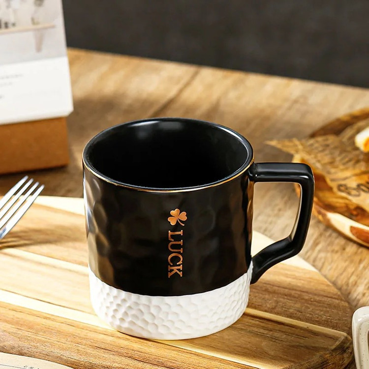 ماگ گلفی لاک رنگ مشکی روی میز چوبی از نمای رو به رو