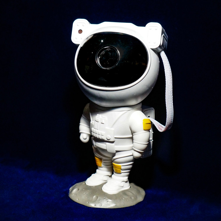 تصویر اختصاصی ثبتشده توسط تیم هیدا گالریا از پروژکتور کهکشانی مدل فضانورد از نمای رو به رو با پشت زمینه ی مشکی و آبی پر رنگ