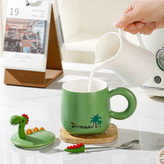 عکس صنعتی ماگ دایناسوری در دار رنگ سبز کمرنگ به همراه در و قاشق محصول در حال پر شدن با شیر توسط کاربر