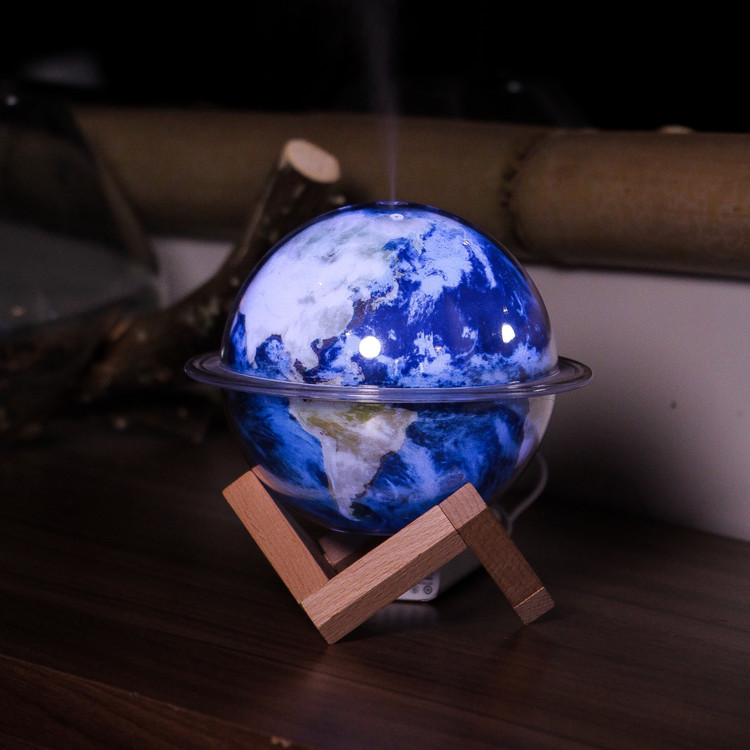 بخورسرد و شب خواب کرهزمین پایه چوبی در حال استفاده کردن از بخور سرد روی میز چوبی از نمای رو به رو