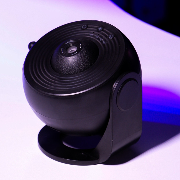 تصویر اختصاصی ثبتشده توسط تیم هیدا گالریا از پروژکتور کهکشانی ١٣ اسلایدی مدل BL-DQY02 رنگ مشکی با پشت زمینه ی سفید و نور آبی و بنفش