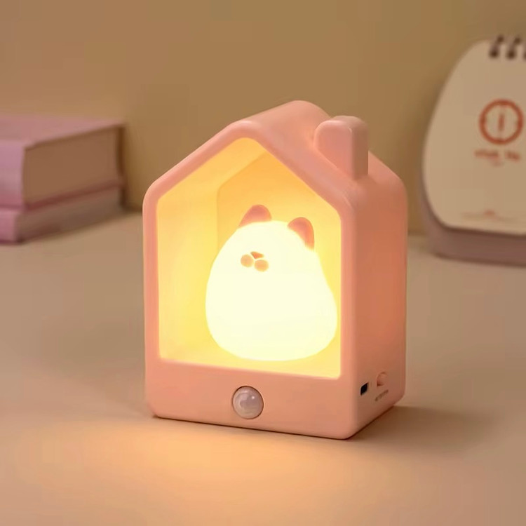 جا کلیدی و شبخواب سیلیکونی گربه رنگ صورتی روی میز سفید و شبخواب روشن از نمای رو به رو