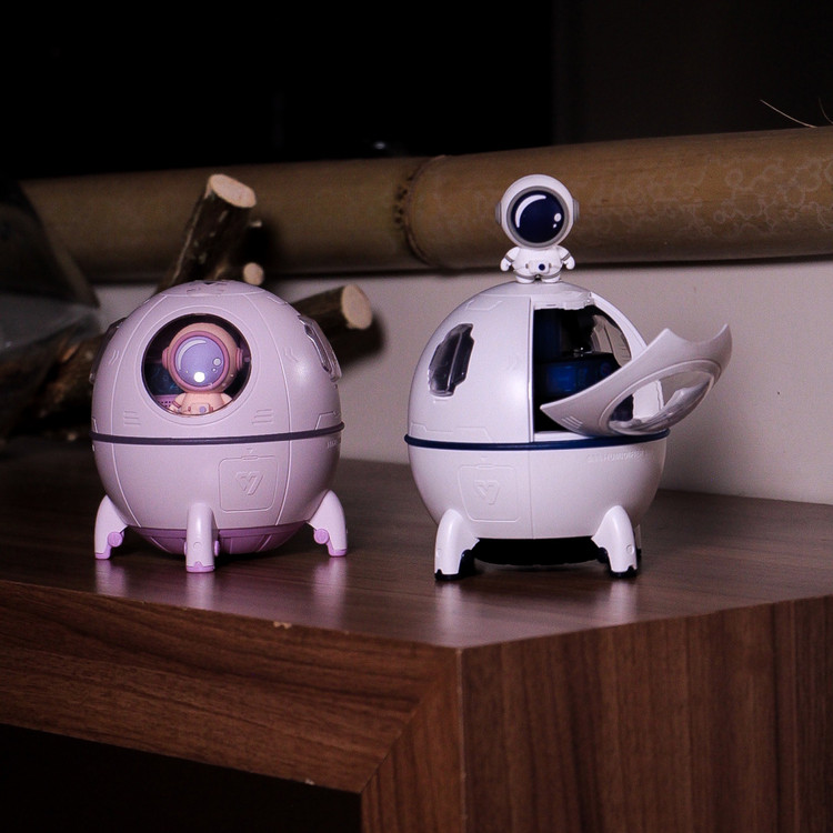 بخور سرد LED دار سفینه فضایی در دو رنگ سفید و بنفش و فضانورد روی سقف بخور سرد LED دار سفینه فضایی رنگ سفید روی میز چوبی