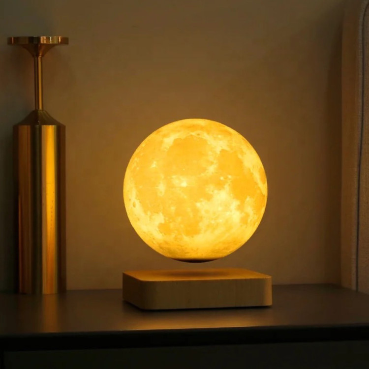 گجت دکوری کره ماه معلق در فضای تاریک اتاق روی میز از نمای رو به رو در حالت روشن