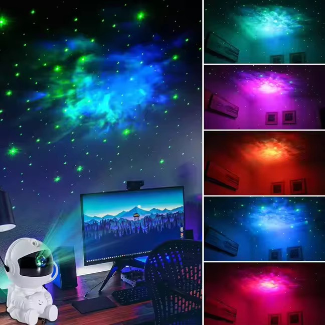 پروژکتور کهکشانی مدل فضانورد نشسته در اتاق روی میز کنار مانیتو کامپیوتر و در حال نمایش مدل ها و رنگ های مختلف کهکشانی در بغل صفحه