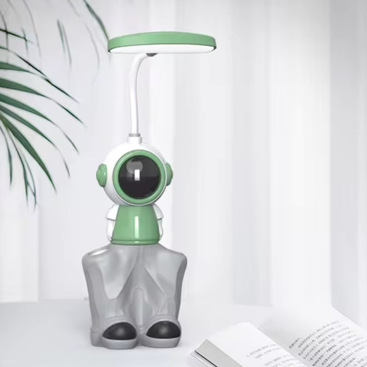 چراغ مطالعه رو میزی ۳ کاره مدل فضانورد رنگ سبز در محیط اتاق روی میز کار