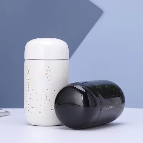 تراول ماگ ۲۰۰ میل Starry Sky در دو رنگ سفید مشکی روی میز سفید