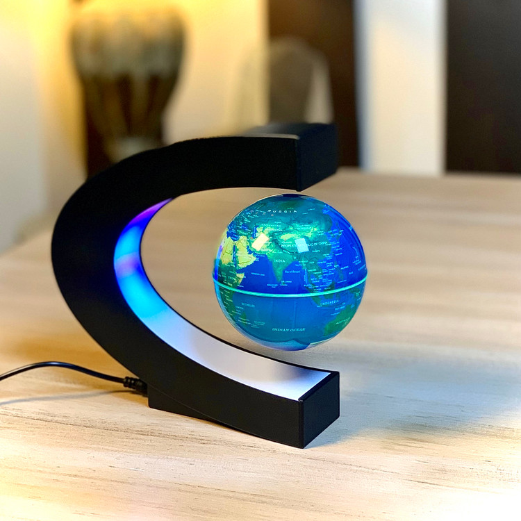 تصویر اختصاصی ثبتشده توسط تیم هیدا گالریا از کره زمین مغناطیسی معلق مدل C در حالت معلق روی میز چوبی